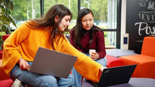Twee studenten met laptop overleggen en wijst naar scherm