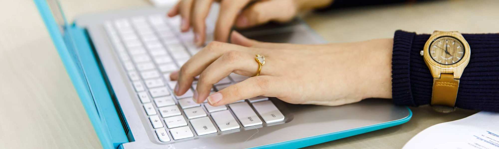 30476 Twee vrouwenhanden typen op het toetsenbord van haar laptop.