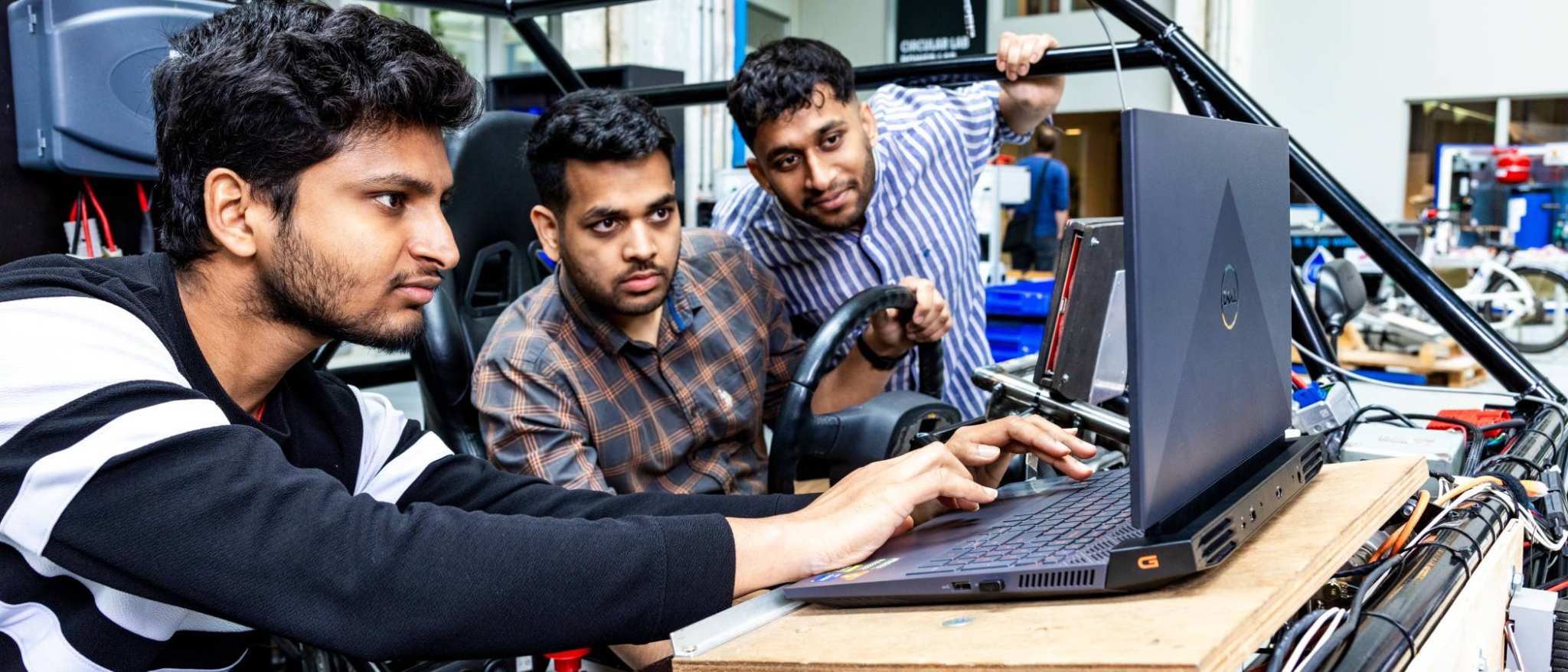 Drie studenten van de Master Engineering Systems Automotive Systems bij de MORE Vehicle.