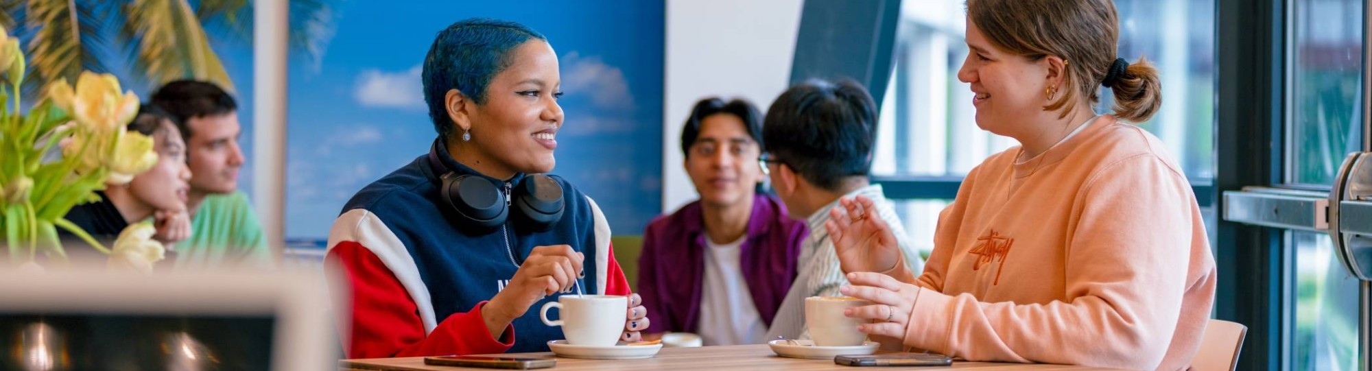 Students Noa, Chadionne, Tam, Diego, Nyugen and Andrei relaxing and drinking coffee in the Hangar on the Arnhem campus of HAN University of Applied Sciences.