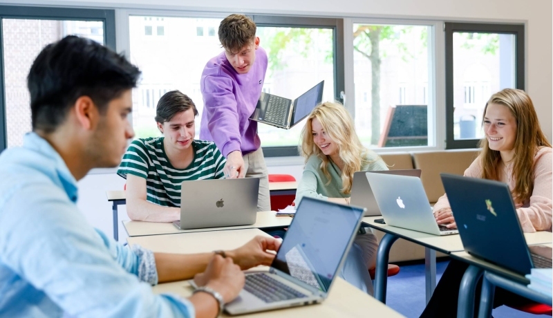 Foto Bedrijfskunde voltijd Nijmegen, klassetting, studenten, samenwerken, laptops