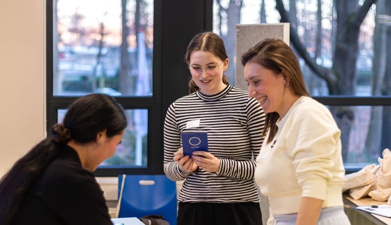 Two master circular economy students playing the 2030 SDGs game and handing over a playing card to the game host