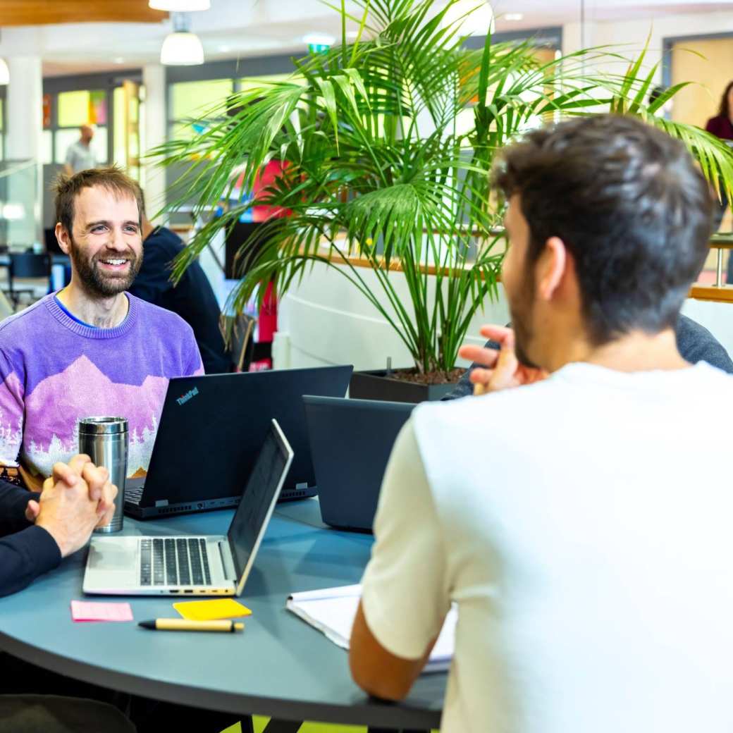 Master Applied Data Science studenten krijgen uitleg van docent en zitten aan ronde tafel met de laptops open