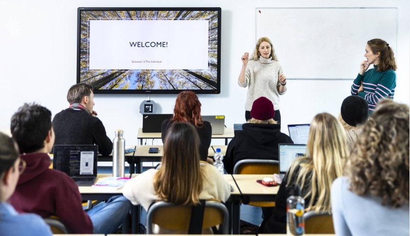 International Social Work. Klas college groep studenten en docent. digiboard op de achtergrond