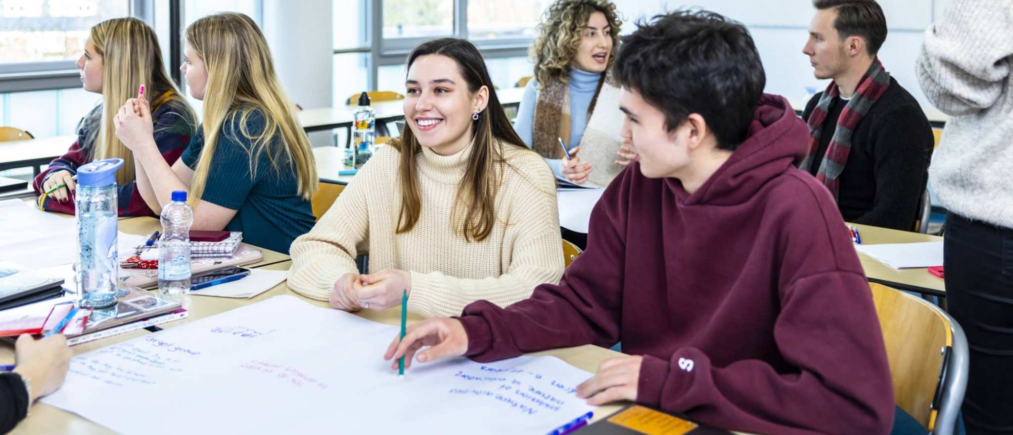 International Social Work. Studenten in collegebanken met praatplaat op tafel