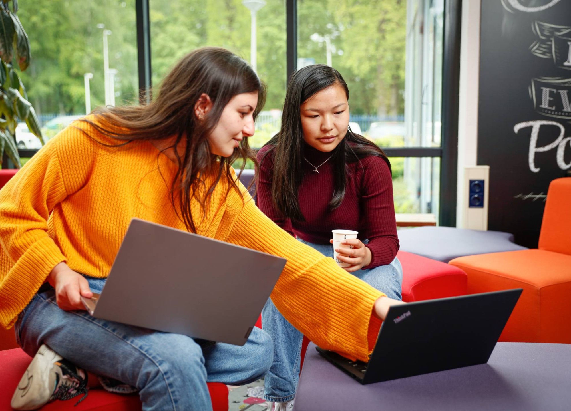 Twee studenten met laptop overleggen en wijst naar scherm