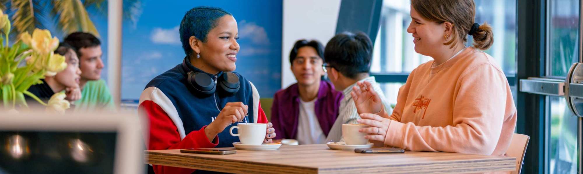 Students Noa, Chadionne, Tam, Diego, Nyugen and Andrei relaxing and drinking coffee in the Hangar on the Arnhem campus of HAN University of Applied Sciences.