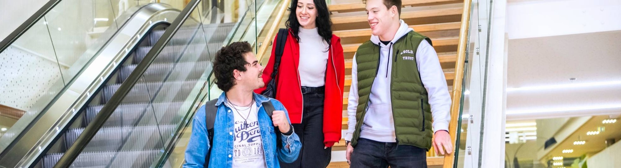 Drie studenten Leraar Natuurkunde lopen samen van de trap af.