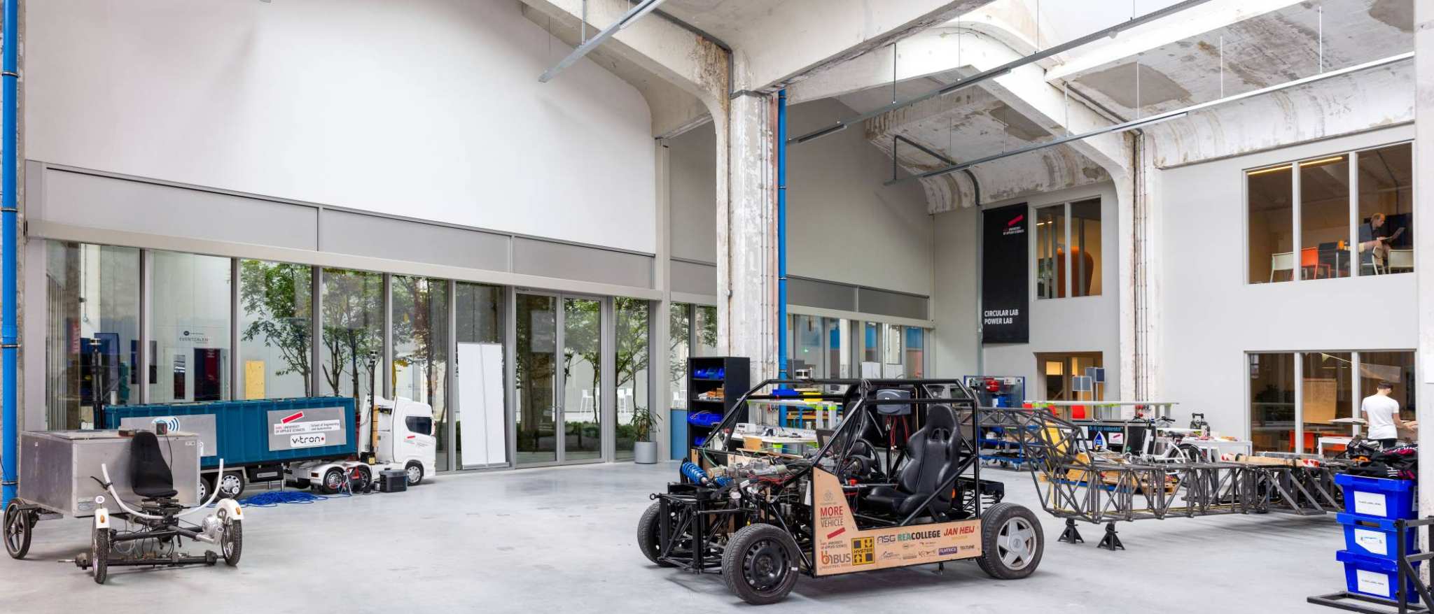 Overzichtsfoto van de grote hal, de grote ruimte, Mobility lab, van HAN Connectr op het IPKW.
In de hal zie je de waterstof bakfiets en de H2-demonstrator, ook zie je het voertuig MORE. Automotive Research