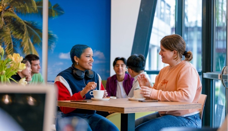 Students Noa, Chadionne, Tam, Diego, Nyugen and Andrei relaxing and drinking coffee in the Hangar on the Arnhem campus of HAN University of Applied Sciences.