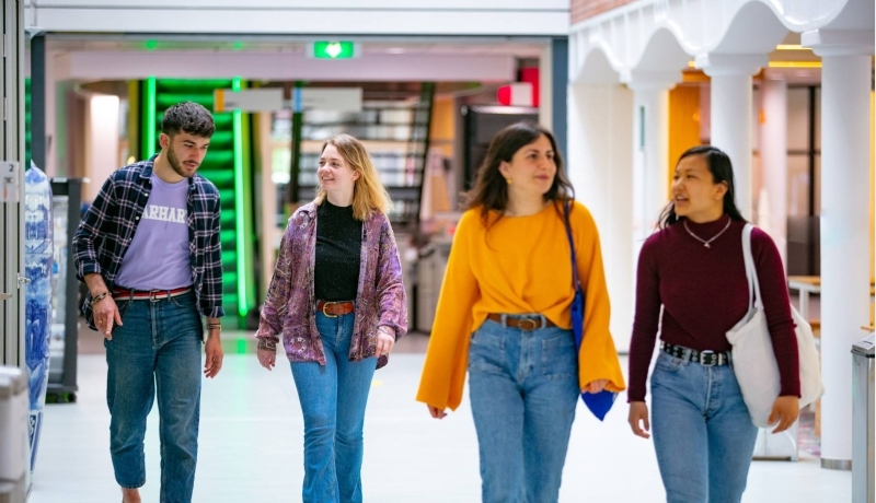 Vier internationale studenten lopen door de gang