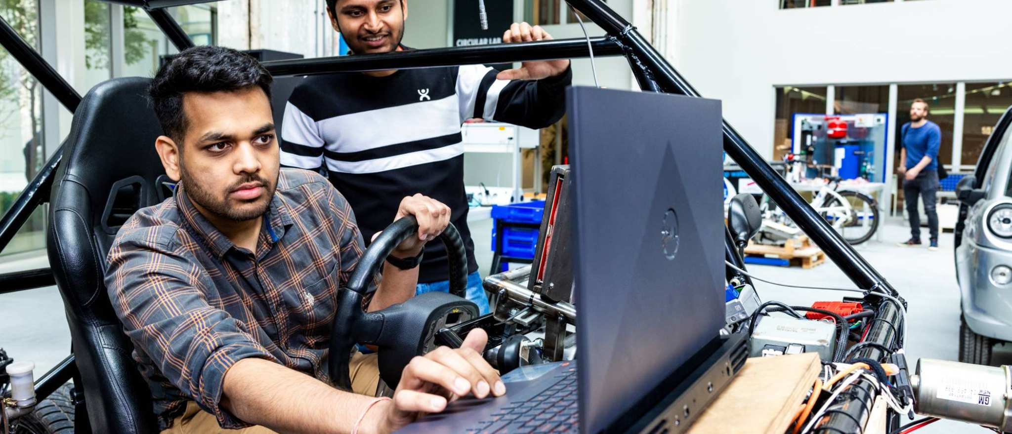 Twee studenten van de Master Engineering Systems Automotive Systems bij de MORE Vehicle.