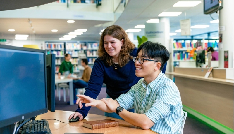 Two master students in Applied Data Science working behind a computer.
