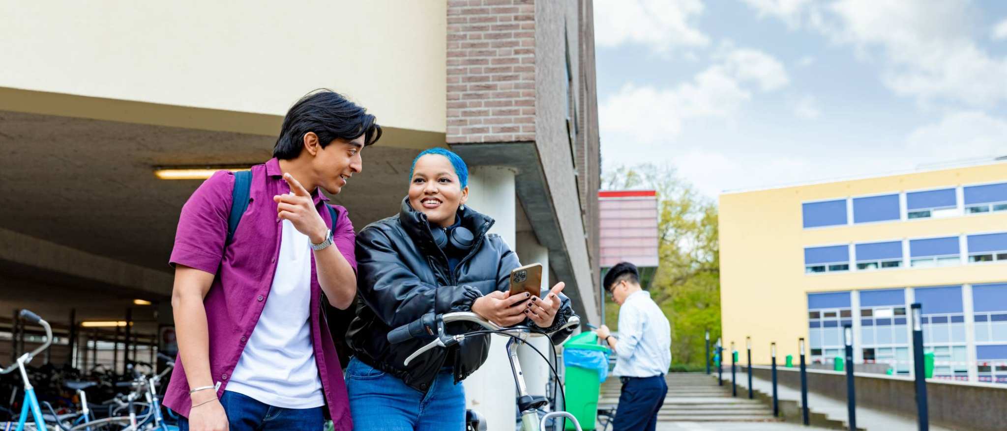 International students Diego and Chadionne with their bikes looking for directions on the Arnhem campus of HAN University of Applied Sciences.