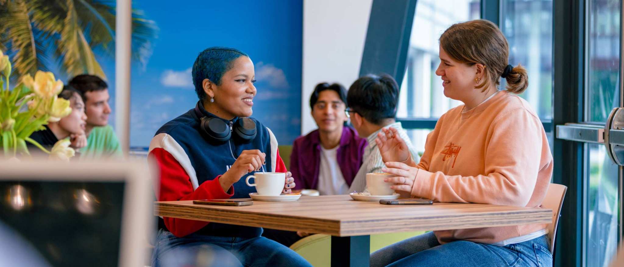 Students Noa, Chadionne, Tam, Diego, Nyugen and Andrei relaxing and drinking coffee in the Hangar on the Arnhem campus of HAN University of Applied Sciences.