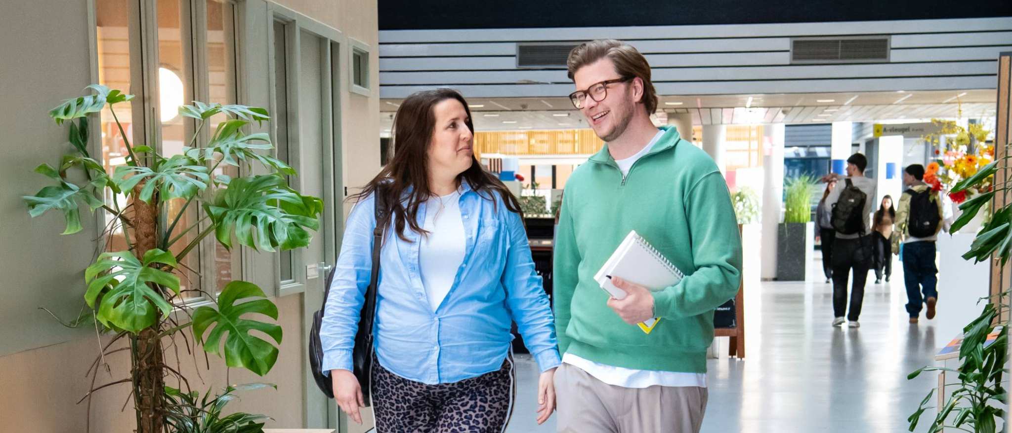 2 masterstudenten lopen op de gang