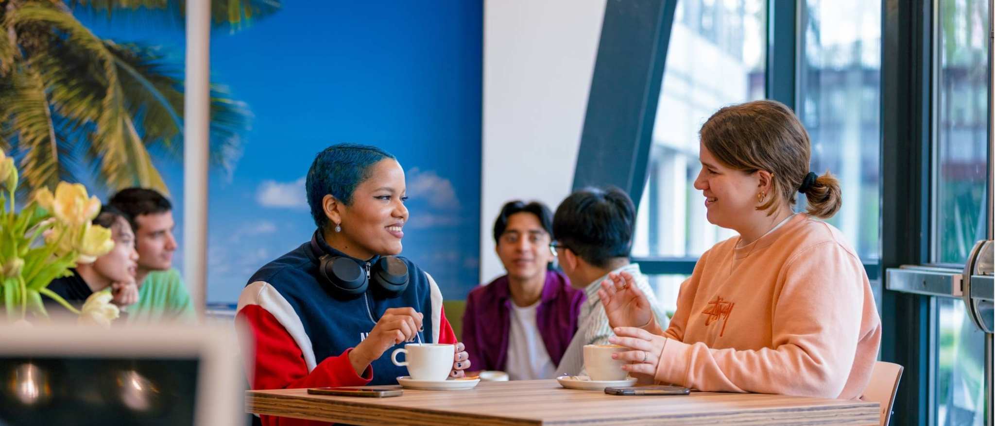 Students Noa, Chadionne, Tam, Diego, Nyugen and Andrei relaxing and drinking coffee in the Hangar on the Arnhem campus of HAN University of Applied Sciences.