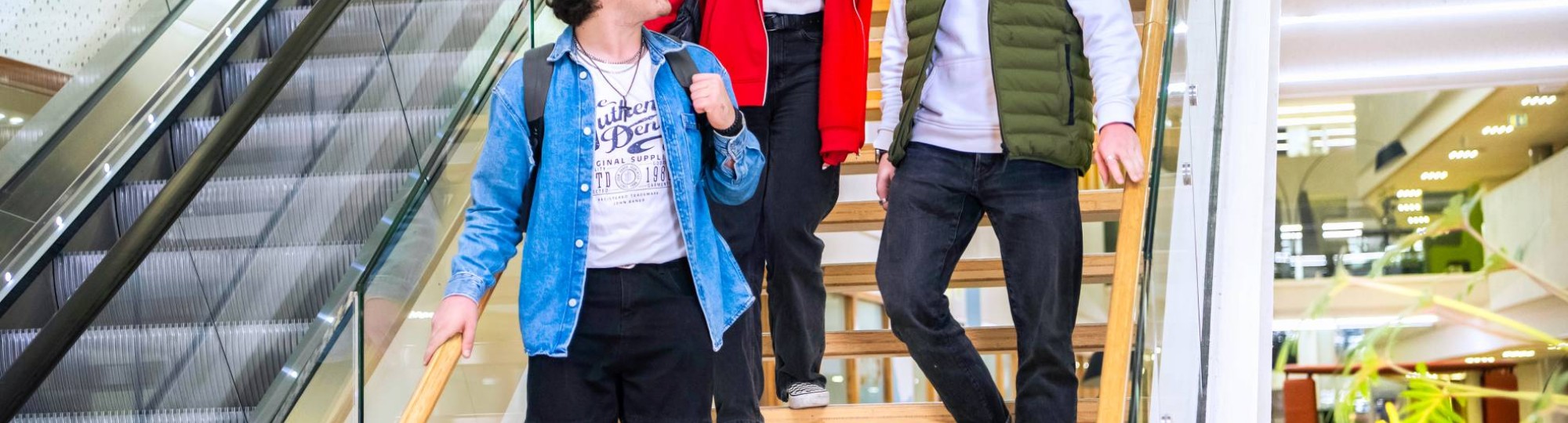 Drie studenten Leraar Natuurkunde lopen samen van de trap af.