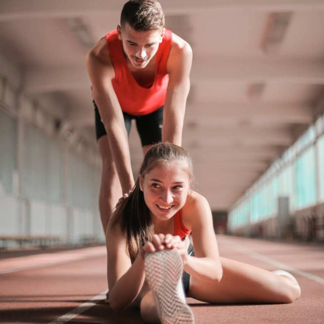 Man en vrouw aan het stretchen en sporten.