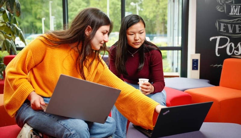 Twee studenten met laptop overleggen en wijst naar scherm