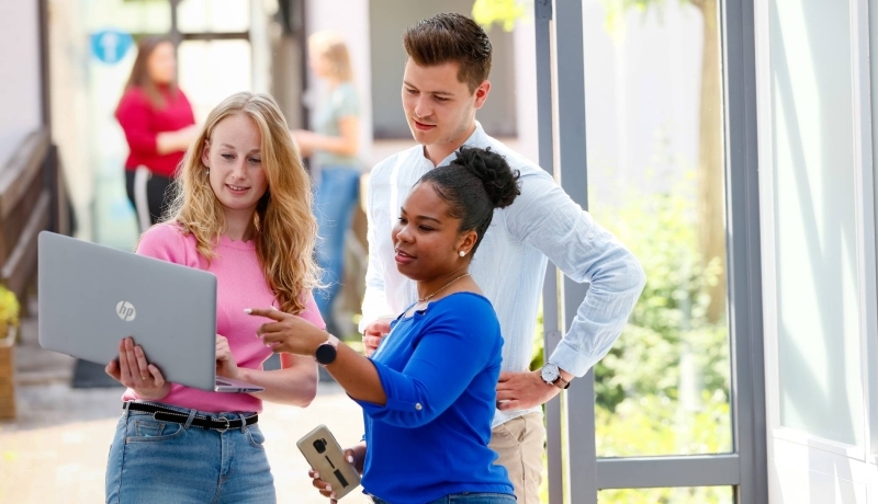 HBO master studenten overleggen via beeldbellen op de laptop in de hal op Han locatie