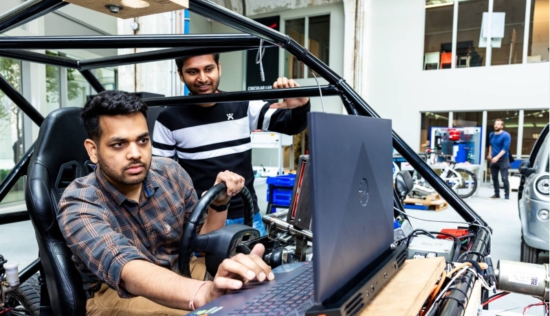 Twee studenten van de Master Engineering Systems Automotive Systems bij de MORE Vehicle.