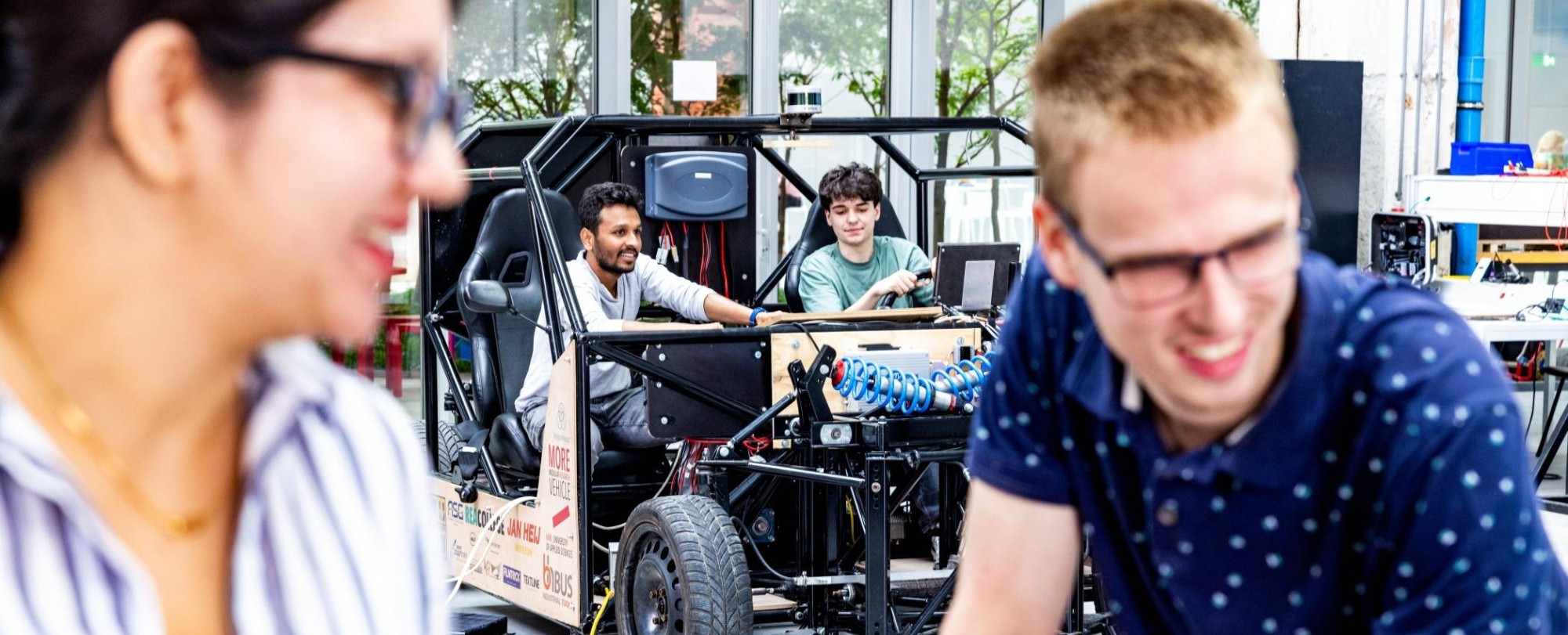 Studenten en docent van de master Engineering Systems Automotive Systems met de MORE Vehicle op de achtergrond.