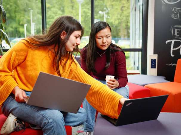Twee studenten met laptop overleggen en wijst naar scherm