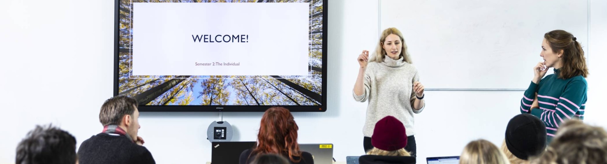 International Social Work. Klas college groep studenten en docent. digiboard op de achtergrond