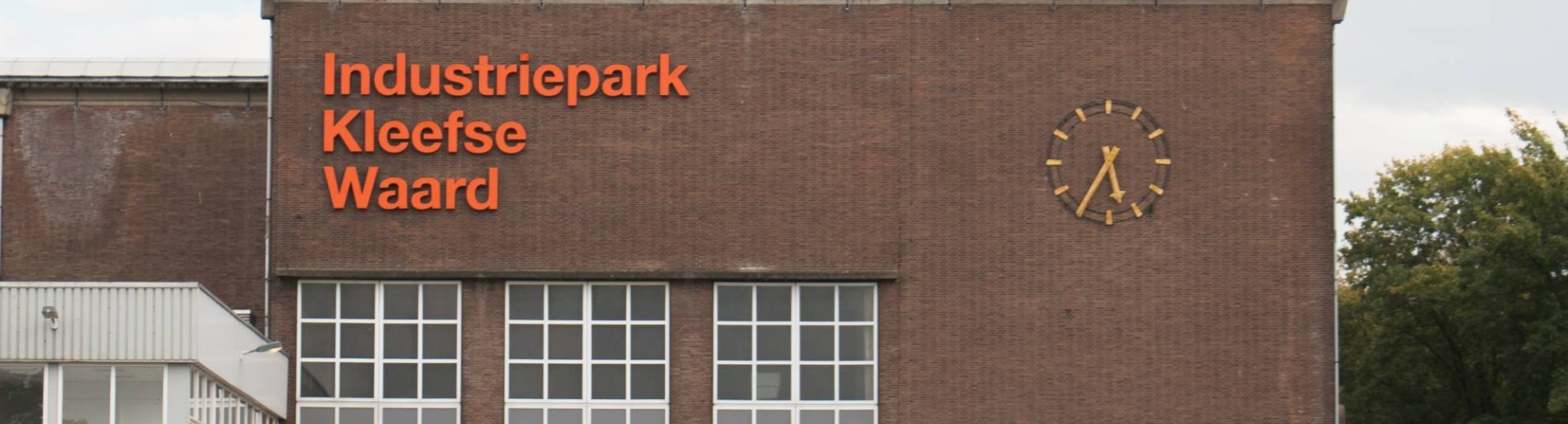 Gebouw op IPKW in Arnhem met klok en oranje letters