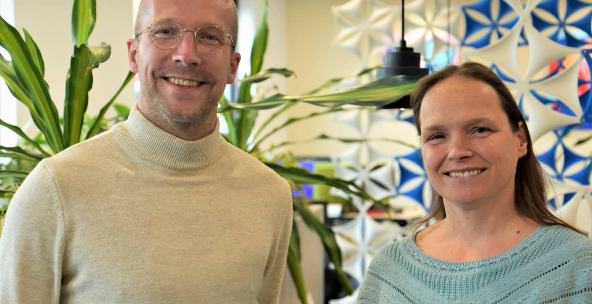 Een foto van Sjors Jansen en Sanne van den Heuvel, 2 docenten International Social Work met kleurrijke achtergrond.